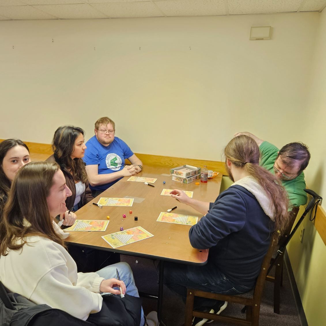 A group of people are sitting around a table playing a game