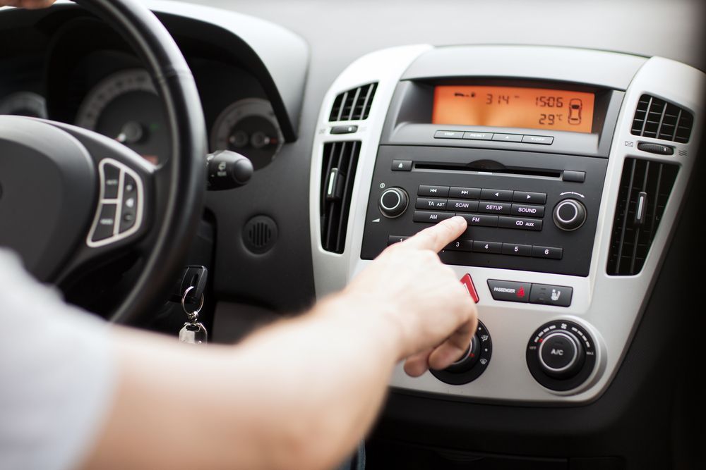A Person is Pressing a Button on a Car Radio — Port Service Centre In Port Macquarie, NSW