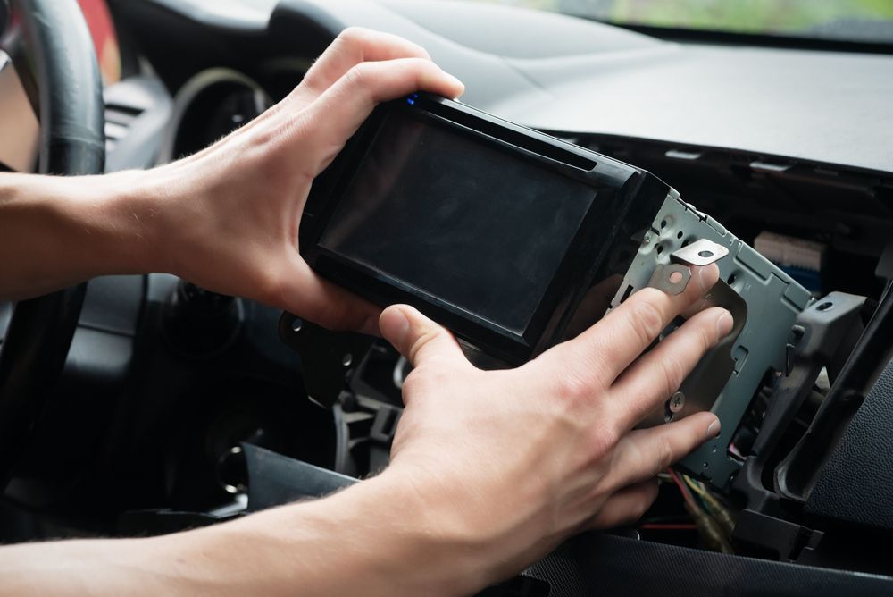 A Person is Installing a Car Radio in a Car — Port Service Centre In Port Macquarie, NSW