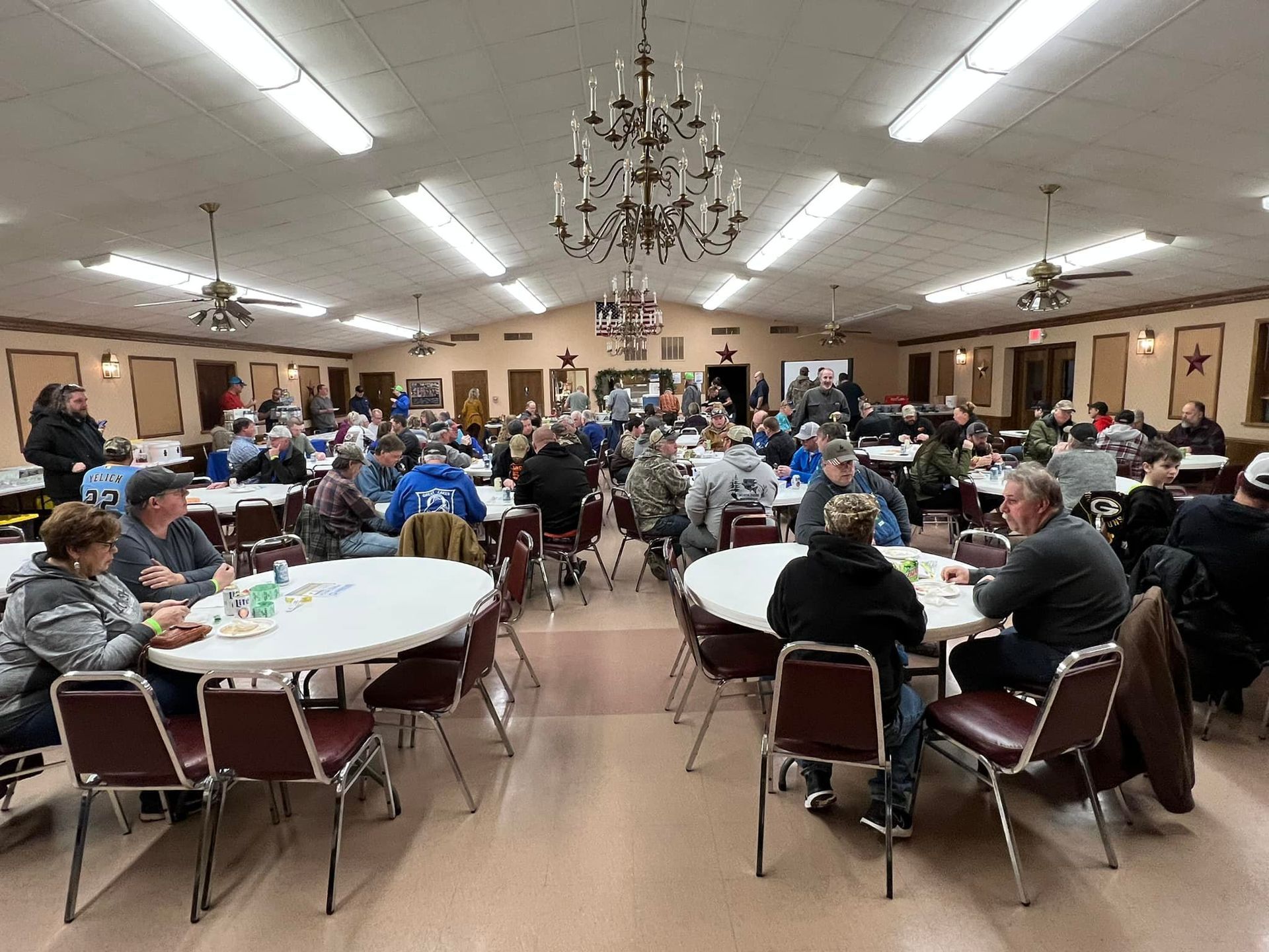 A large group of people are sitting at tables in a large room.