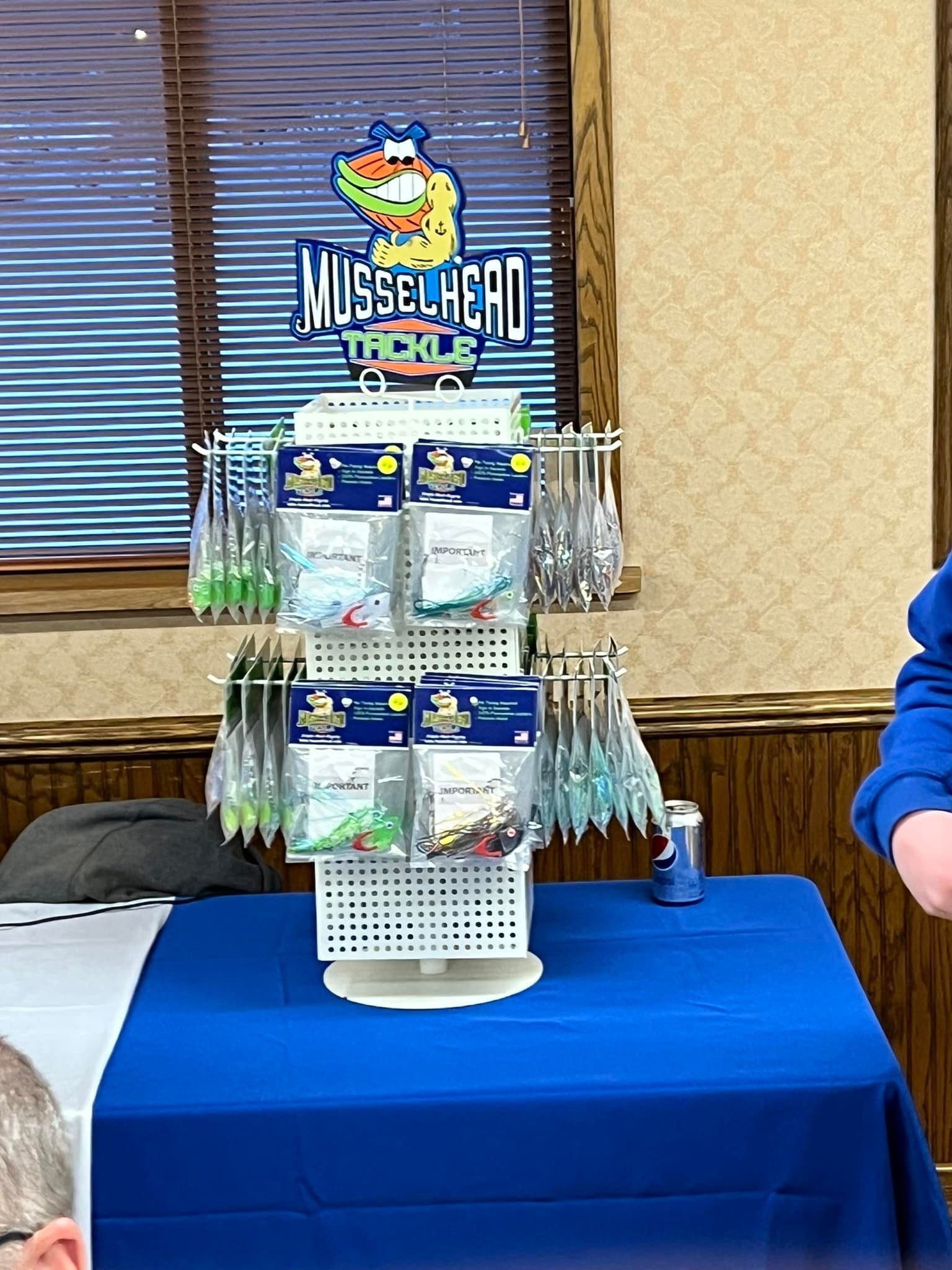 A table with a blue tablecloth and a display of fishing lures on it.