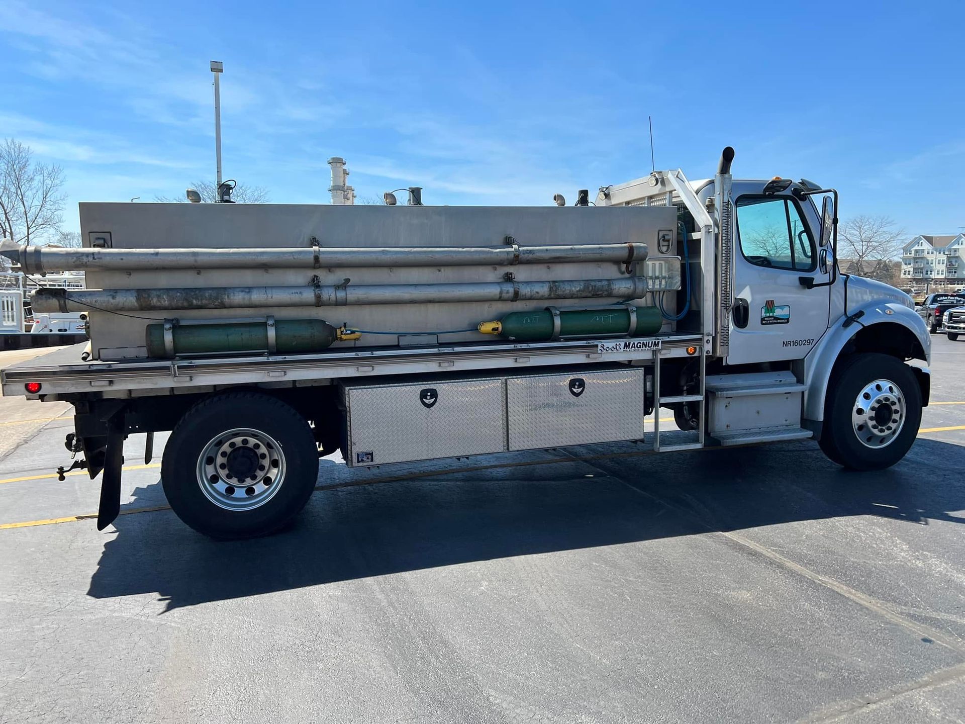 A silver truck is parked in a parking lot.