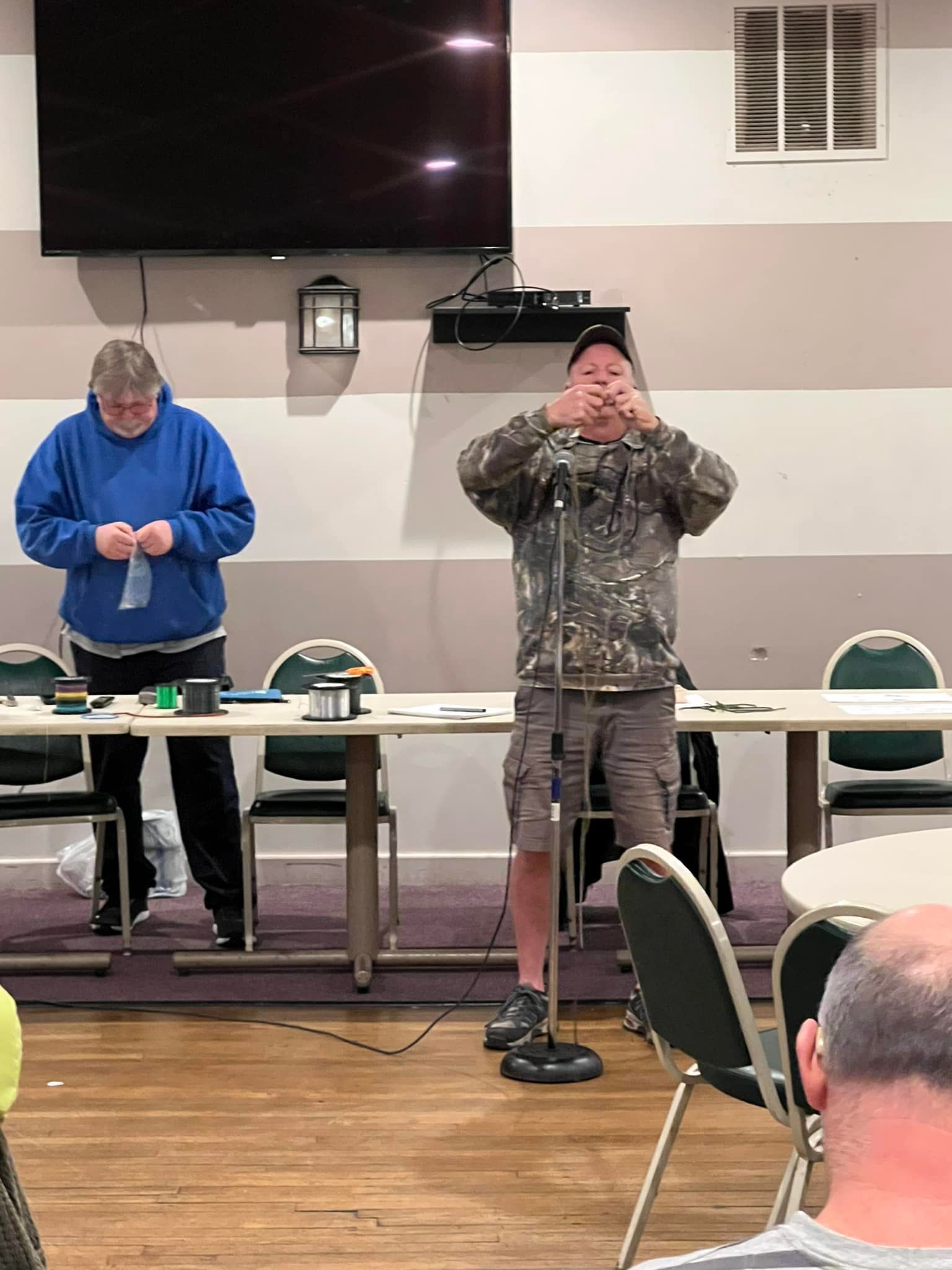 A man is standing in front of a microphone in a room.
