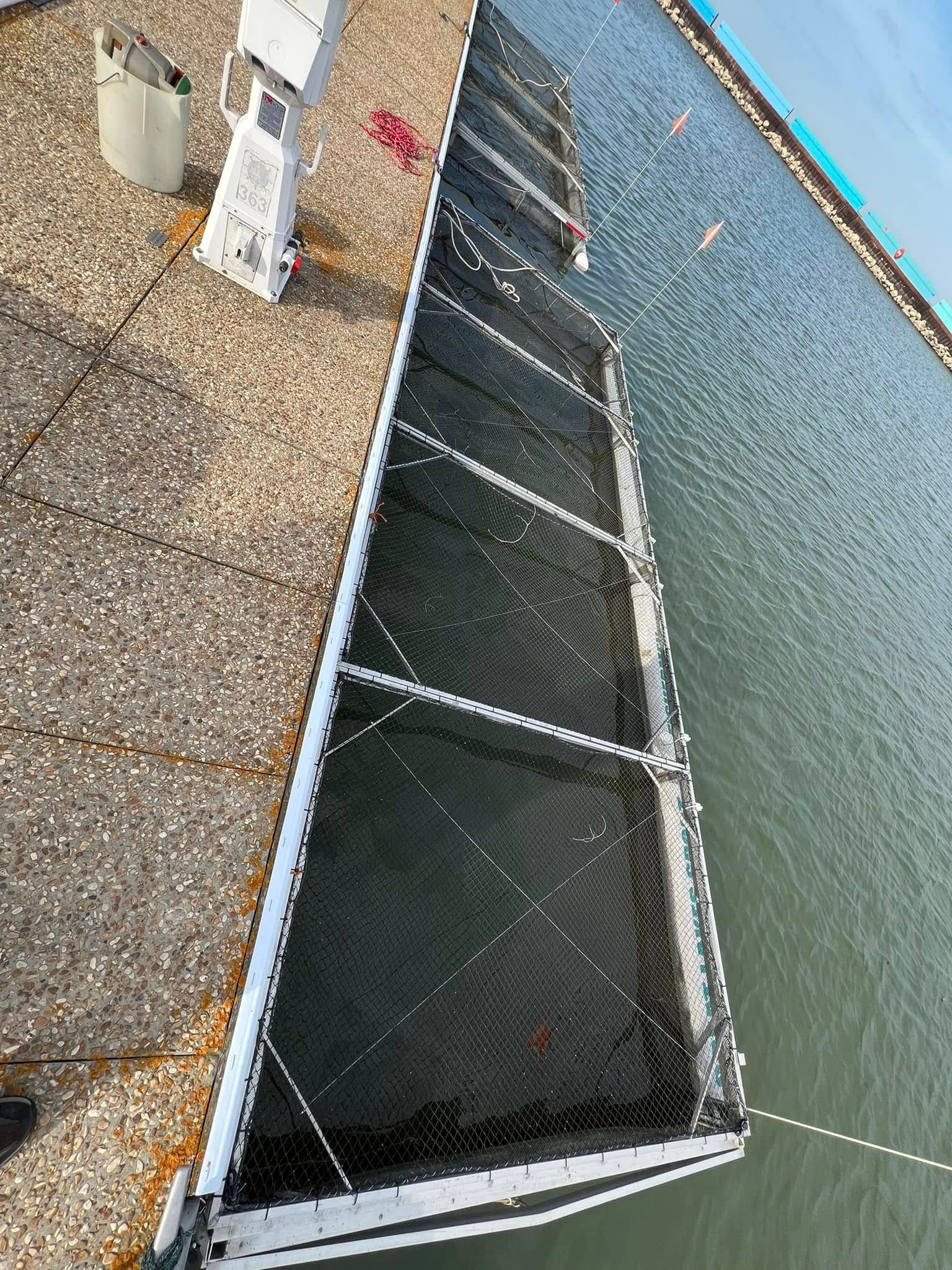 A sailboat is docked at a dock next to a body of water.