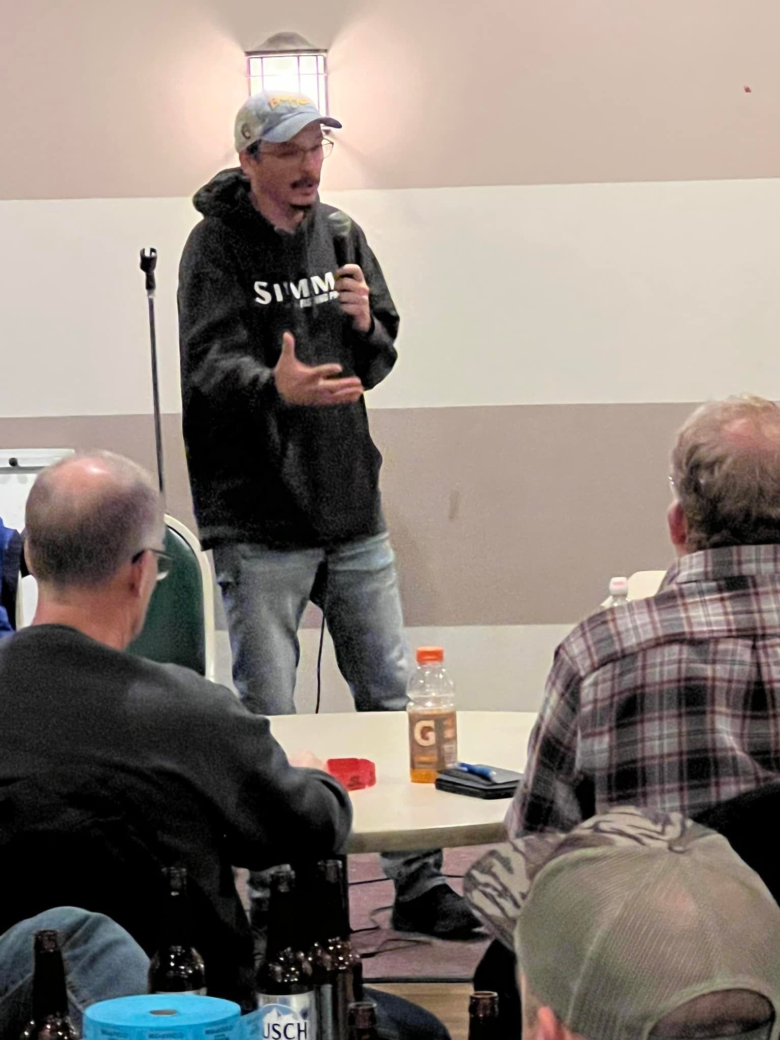 A man is giving a presentation to a group of people sitting at a table.