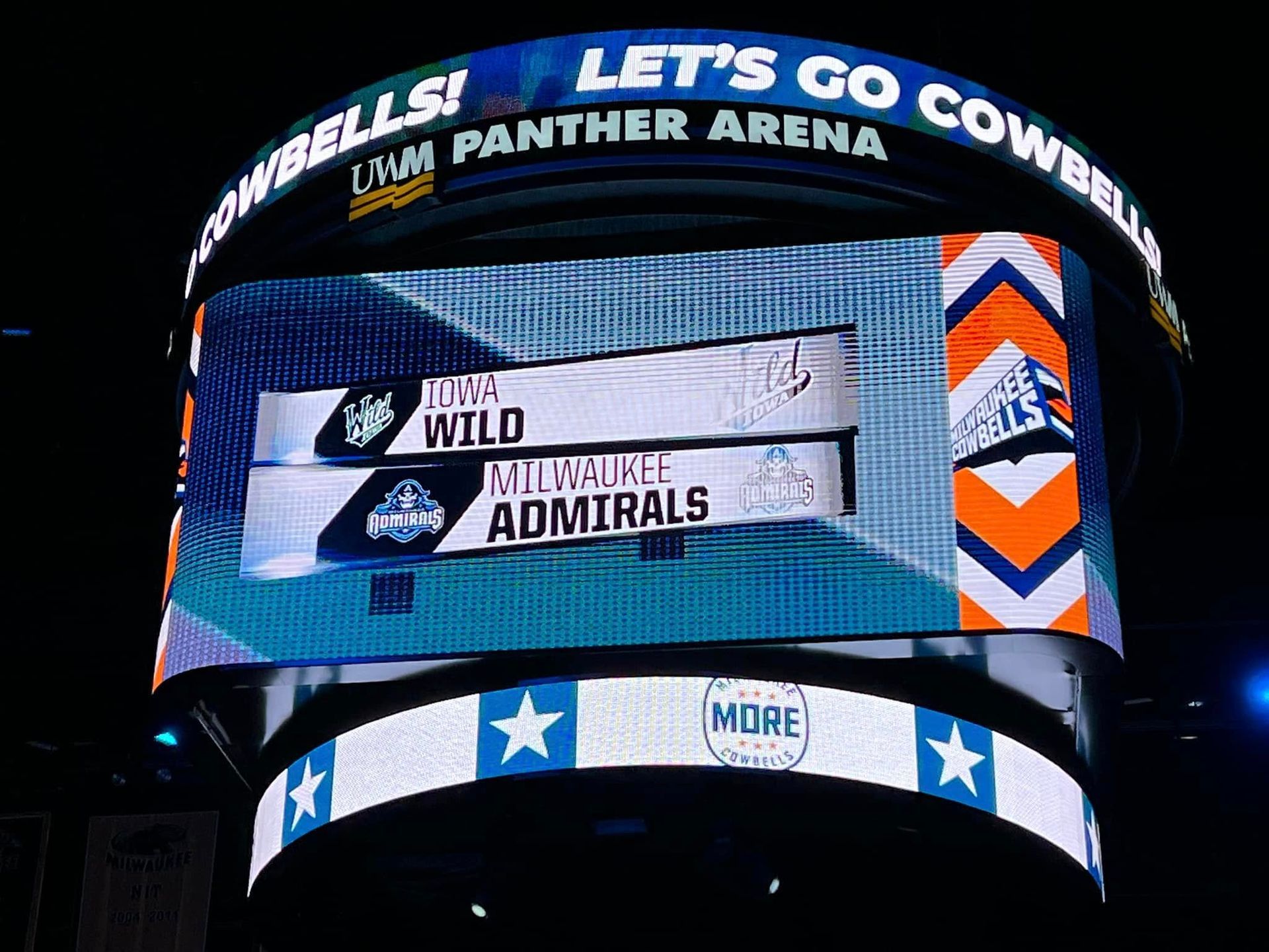 A large screen says let 's go cowbells at the panther arena