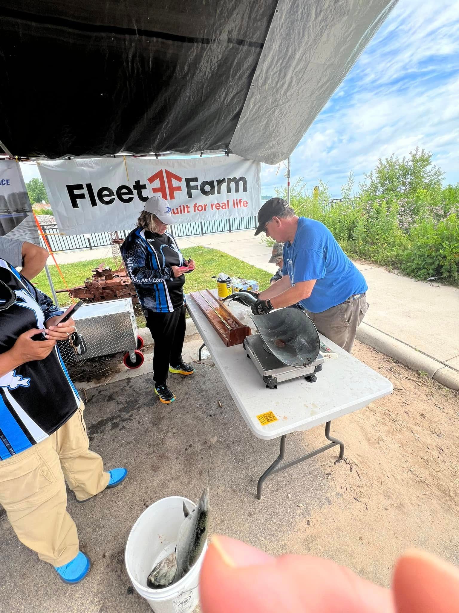 A group of people are standing around a table under a tent.
