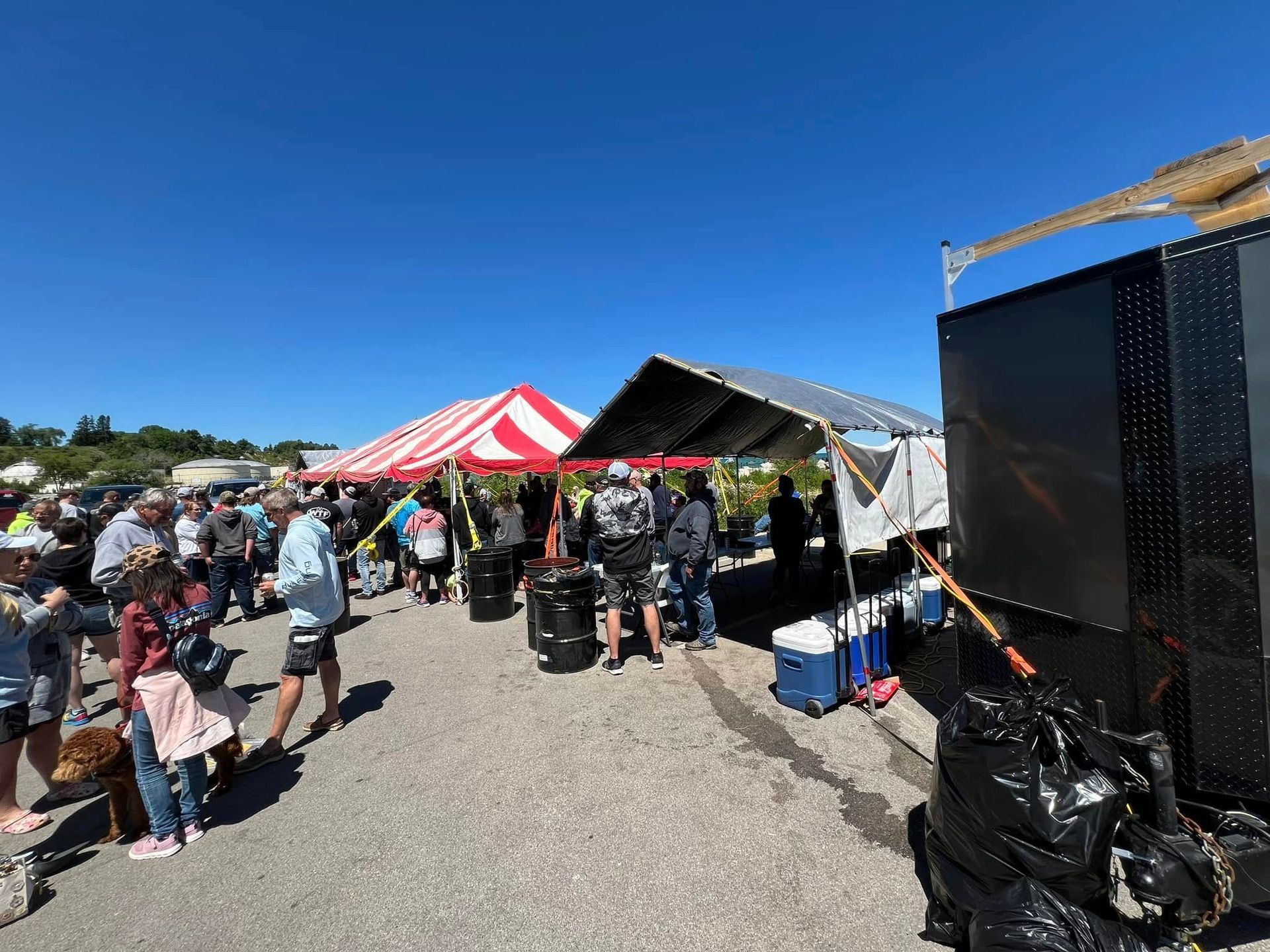 A group of people are standing under tents at a festival.