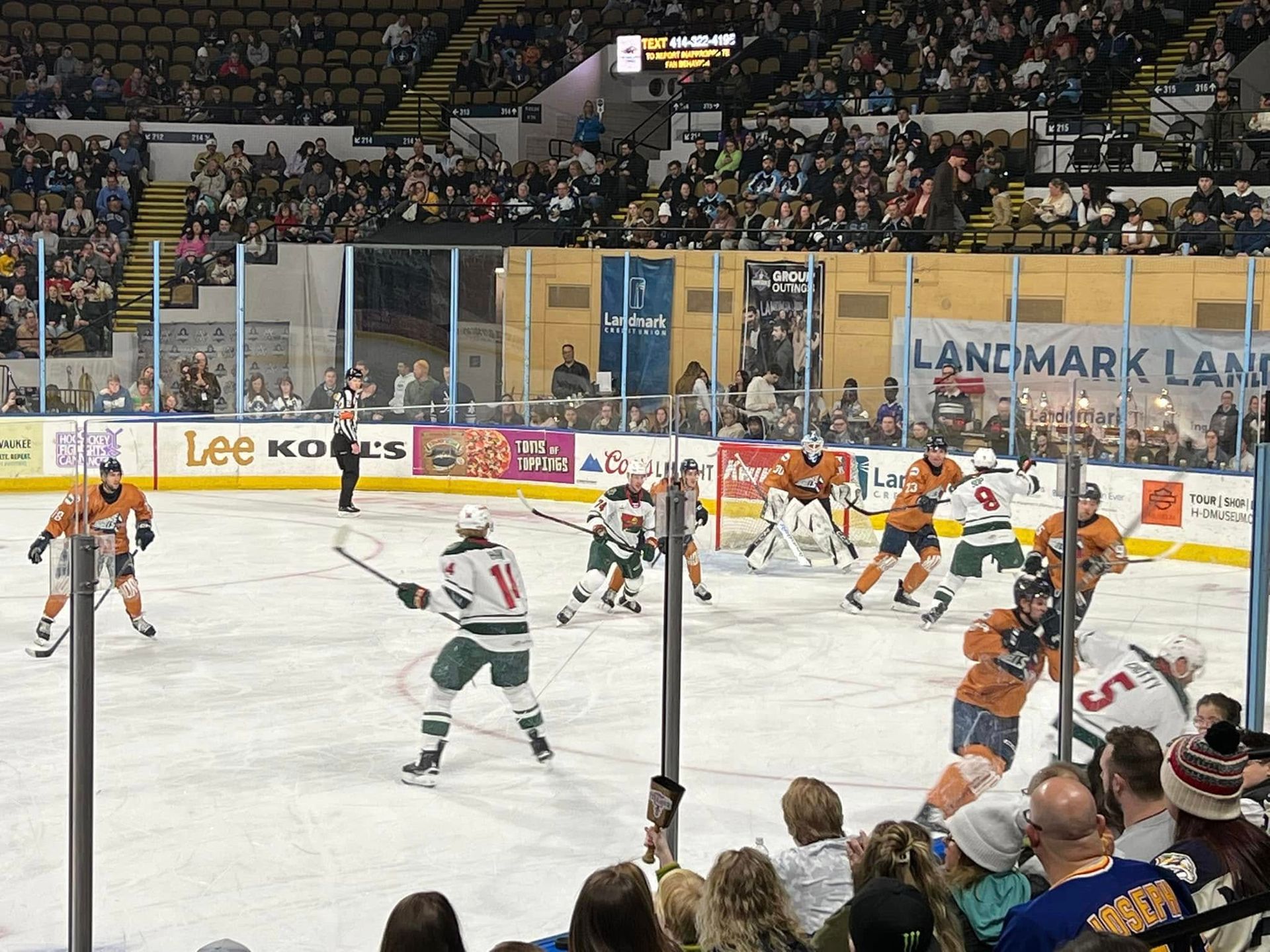 A hockey game is being played in a stadium with a sign that says landmark land