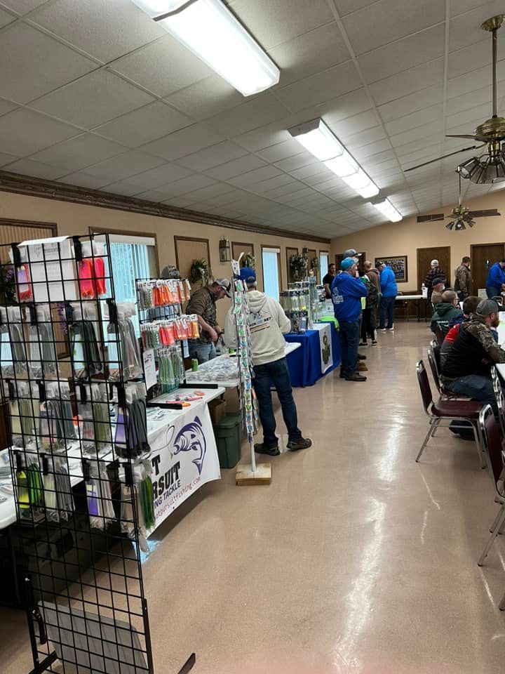 A group of people are standing around tables in a room.