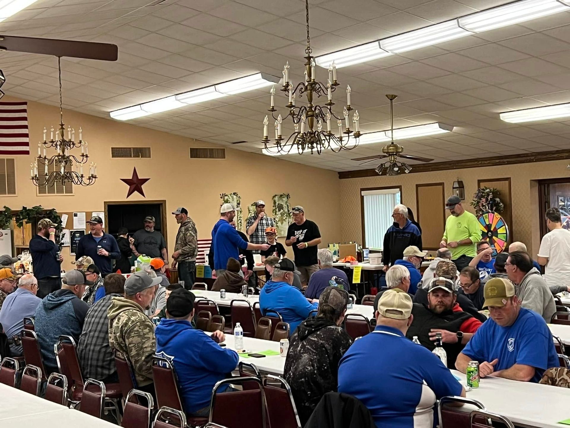 A group of people are sitting at tables in a large room.