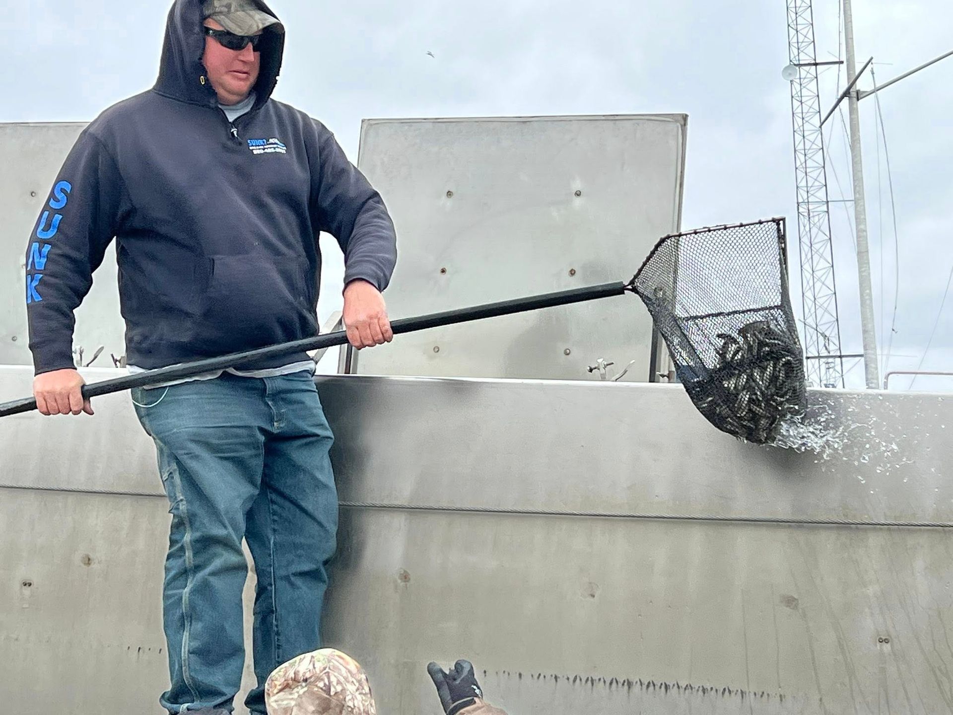 A man is holding a fishing net over a body of water.
