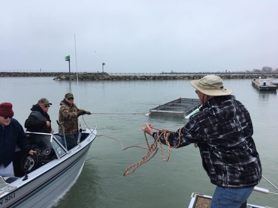 A group of men are pulling a boat in the water.