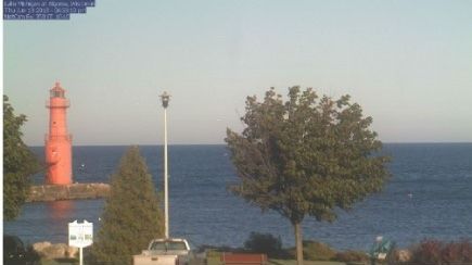 A lighthouse is visible in the distance overlooking the ocean.