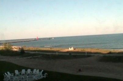 A view of the ocean from a balcony with a circle of chairs in the foreground.