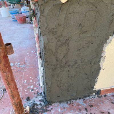 In un cantiere edile si sta intonacando un muro.