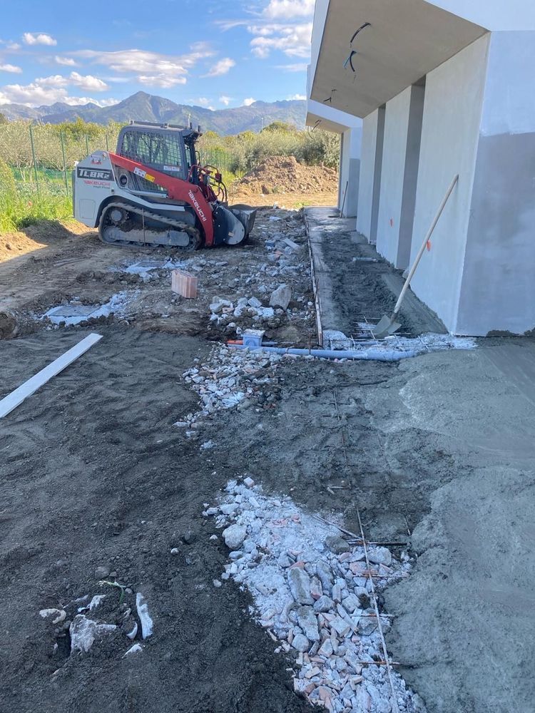 Una ruspa è parcheggiata davanti a un edificio in costruzione.