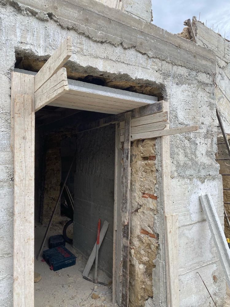 Una porta di legno viene costruita in un muro di pietra.