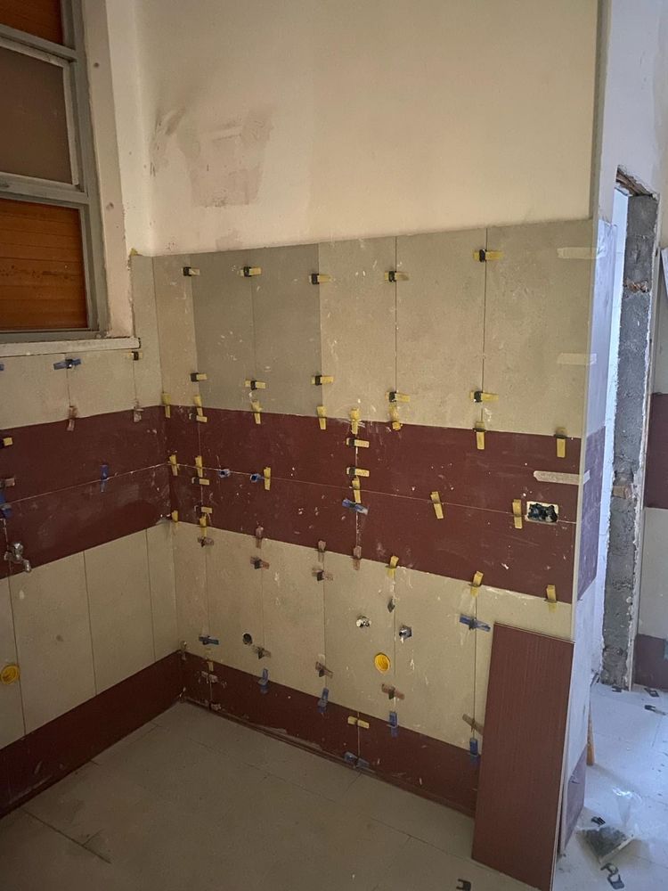 Una cucina con un sacco di piastrelle sul muro e una finestra.