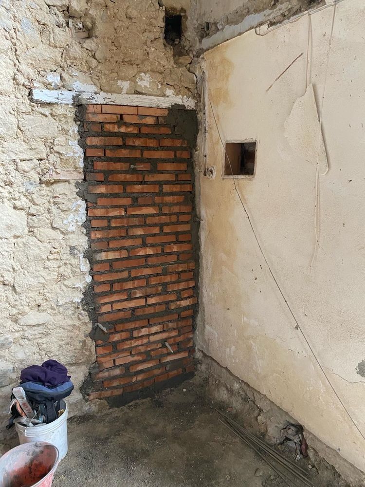 In una stanza viene costruito un muro di mattoni.