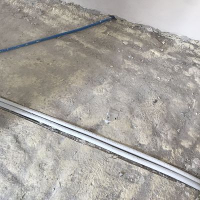 Un tubo è appoggiato a terra vicino a un muro.