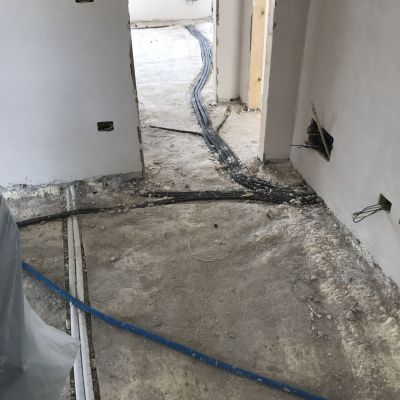 Un tubo è appoggiato sul pavimento in una stanza in costruzione.