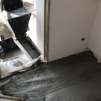 Una macchina sta versando cemento in una stanza.