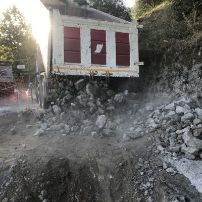 Un camion con cassone ribaltabile è parcheggiato in cima a un mucchio di rocce.