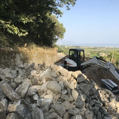 Un bulldozer è seduto in cima a un mucchio di rocce