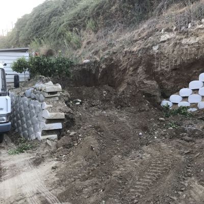 Un camion sta percorrendo una strada sterrata accanto a un mucchio di rocce.