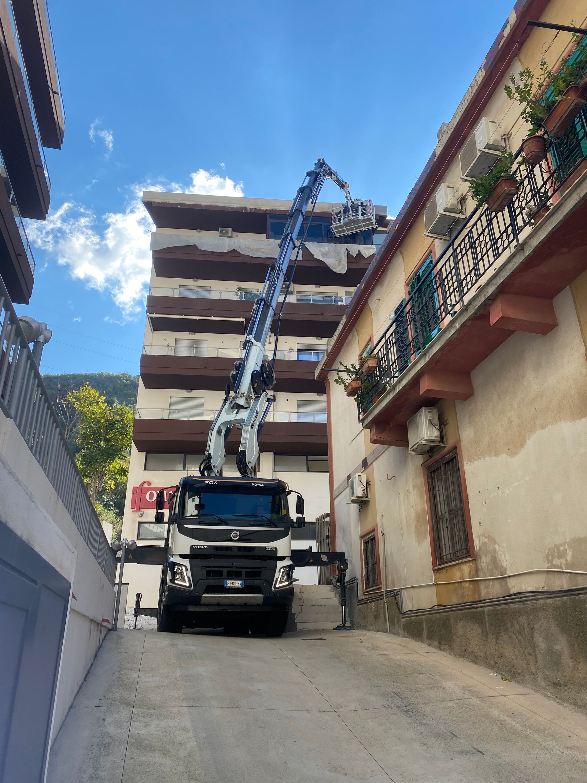 Un camion con una gru sopra è parcheggiato davanti a un edificio
