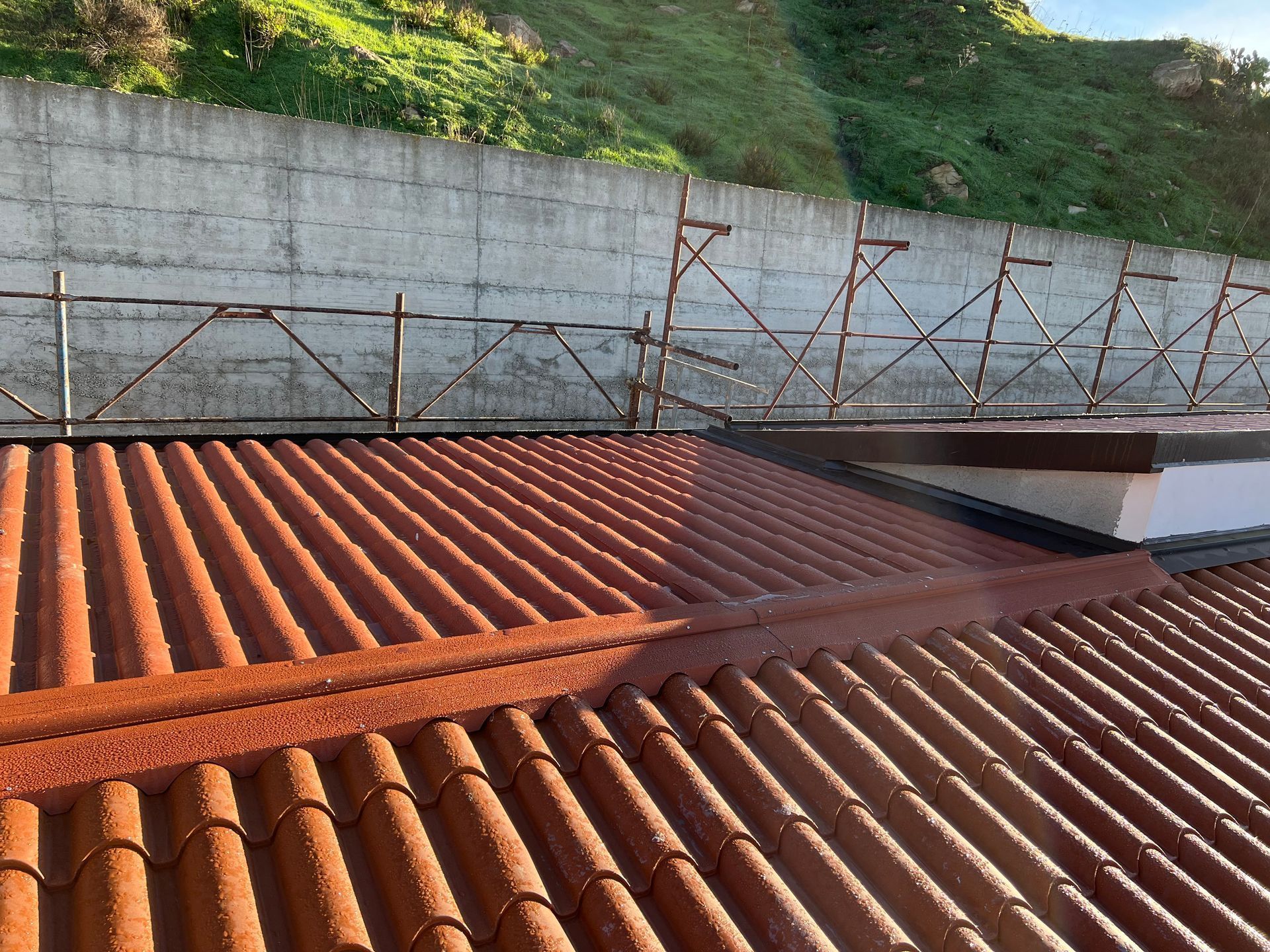 Un tetto di tegole rosse con un muro di cemento sullo sfondo