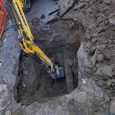 Un escavatore giallo sta scavando una buca nel terreno.
