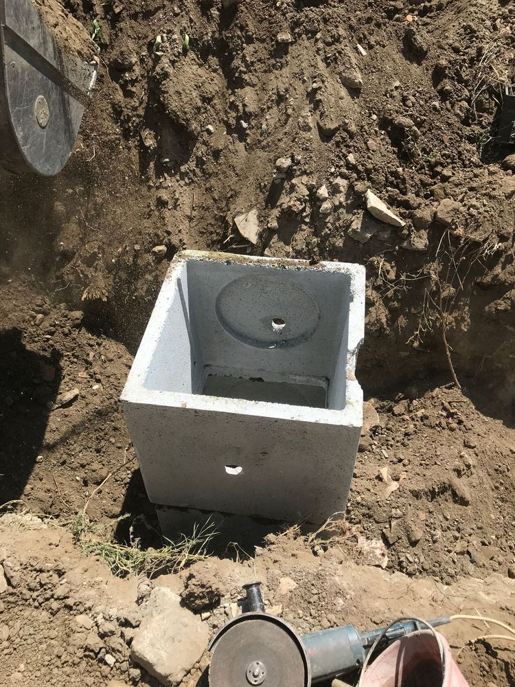 Una scatola di cemento è posta in mezzo a un mucchio di terra.