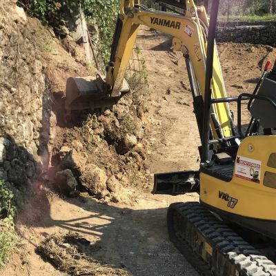 Un escavatore yanmar giallo sta scavando una buca nel terreno