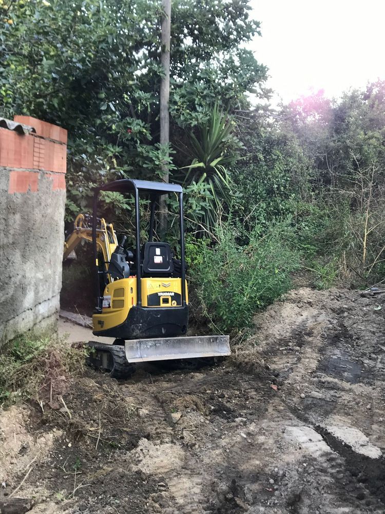 Un piccolo bulldozer giallo sta percorrendo una strada sterrata.