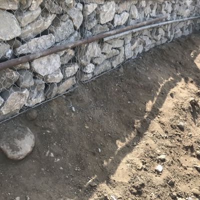 Un muro di pietra viene costruito accanto a un mucchio di terra.