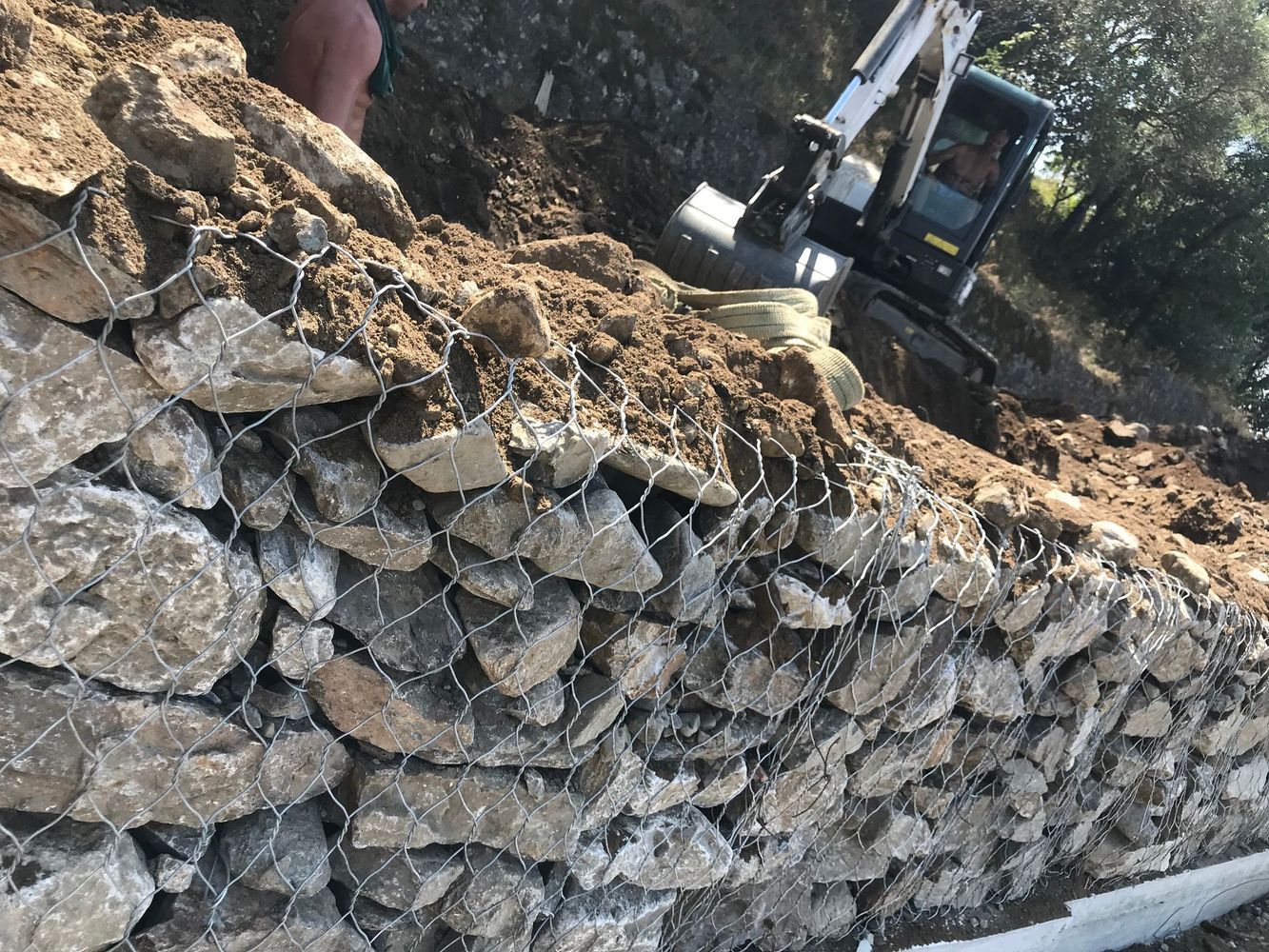 Un escavatore sta scavando una buca in un mucchio di rocce