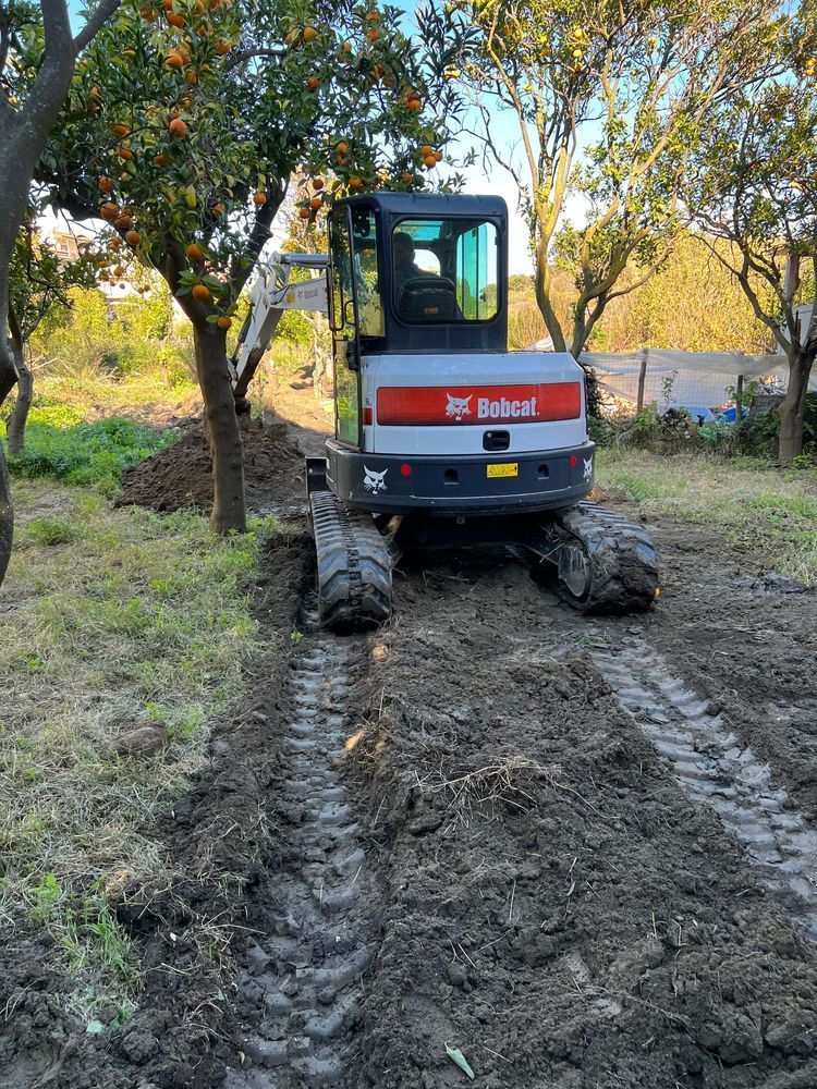 Un escavatore Bobcat sta attraversando un campo fangoso.