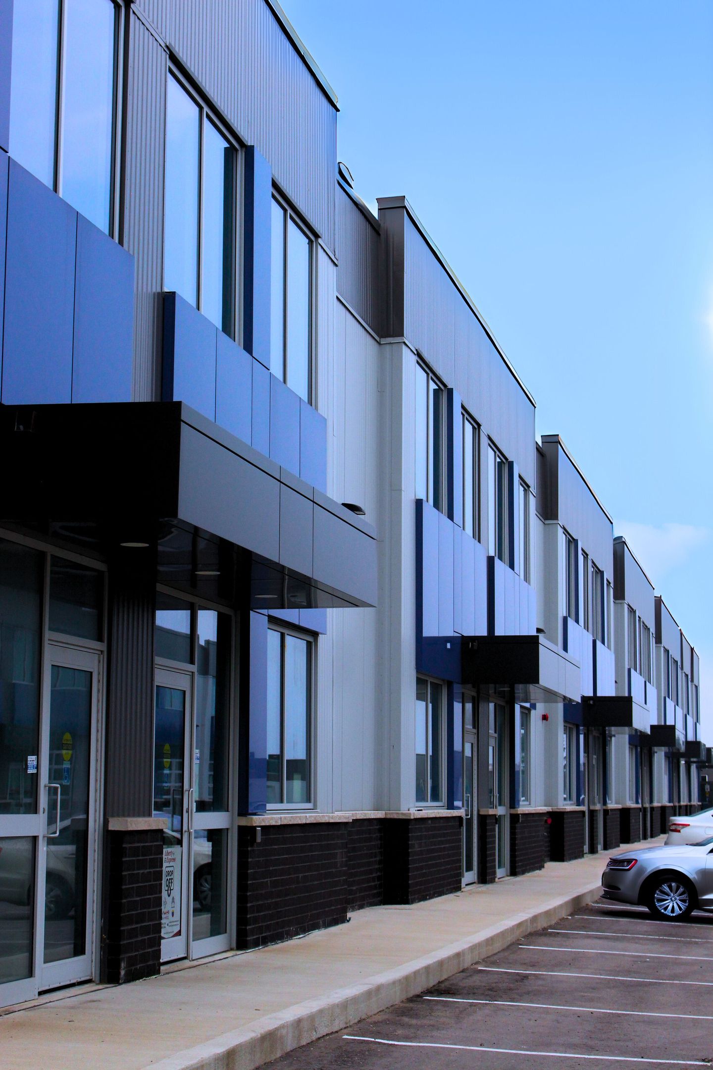 an outside side view of units with blue panelling, lots of windows and doors