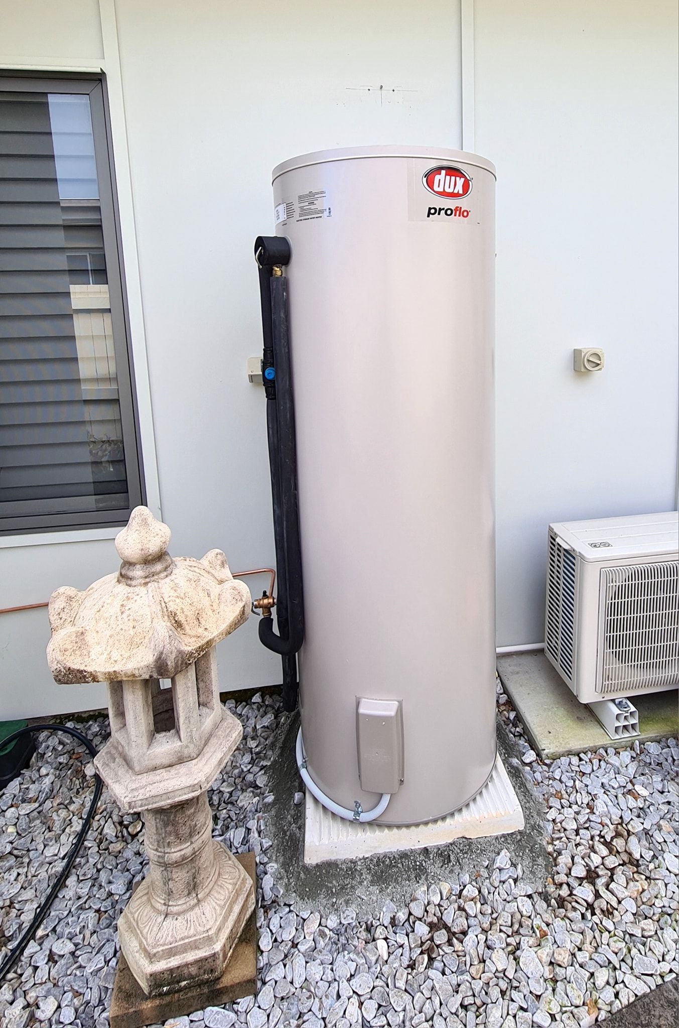 White Water Heater With Black Pipes and Brass Fittings, in a Wooden Enclosure — 24/7 Hot Water in Valdora, QLD
