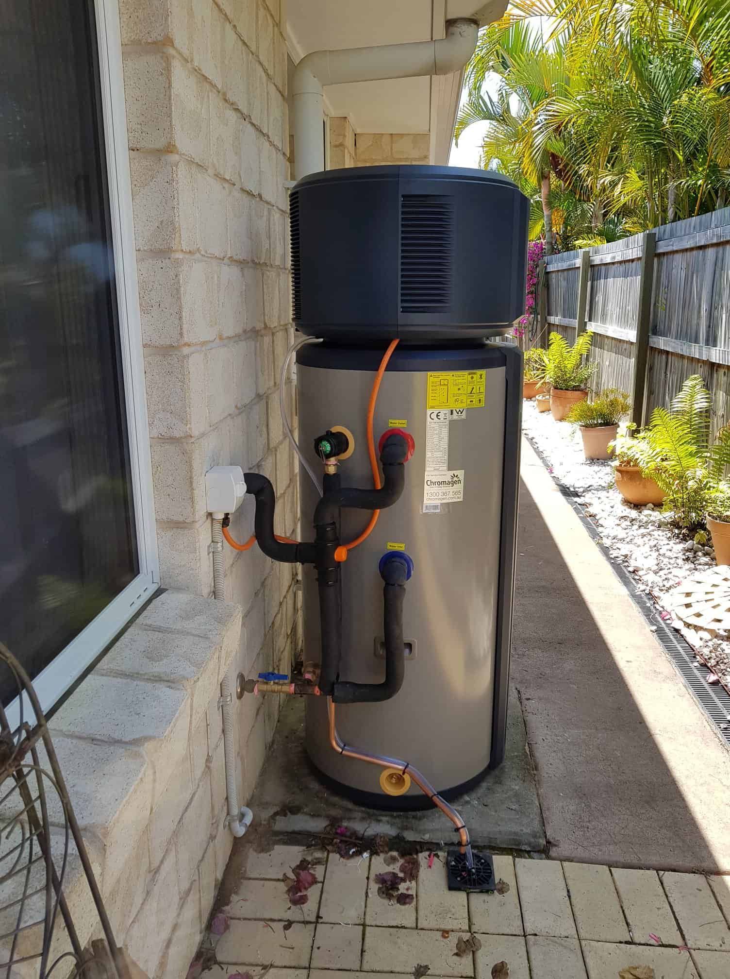 A heat pump water heater unit installed on an exterior wall of a house. — 24/7 Hot Water in Maroochydore, QLD