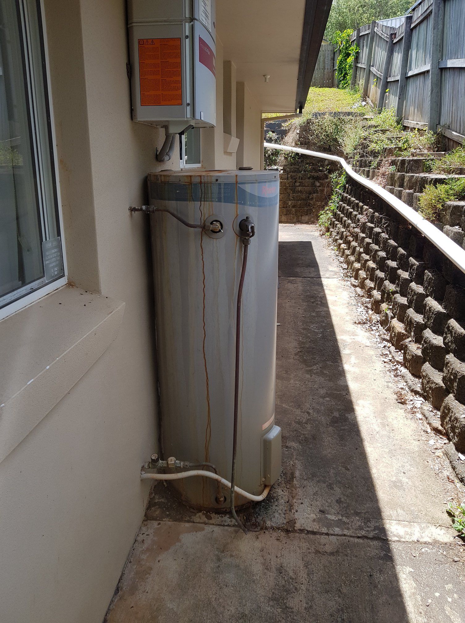 Water Heater Next to a Building Wall and Pathway — 24/7 Hot Water in Valdora, QLD