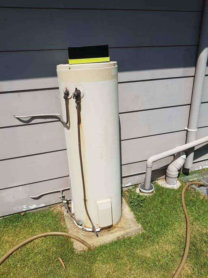 A White Water Heater With Black Pipes and a Bronze Valve — 24/7 Hot Water in Maroochydore, QLD