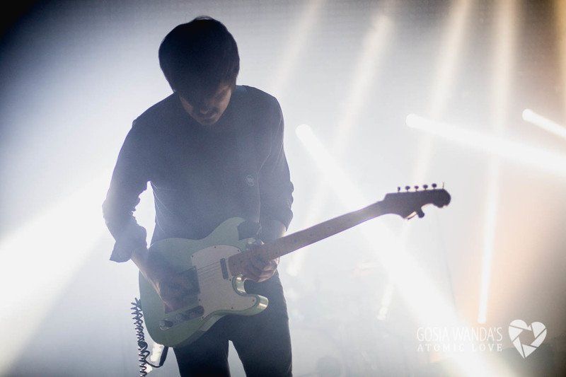 a man is playing an electric guitar on a stage .