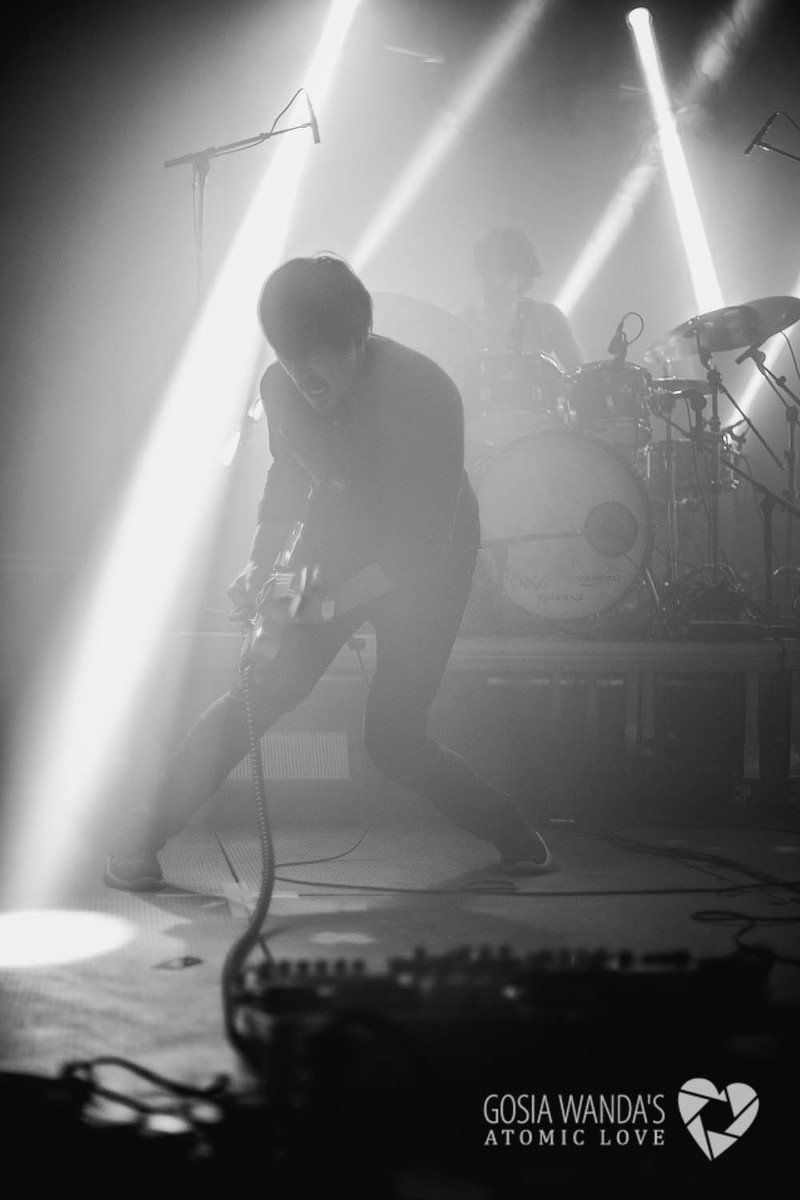 a black and white photo of a man playing a guitar