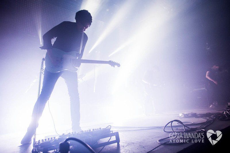 a man is playing a guitar on a stage in a dark room .