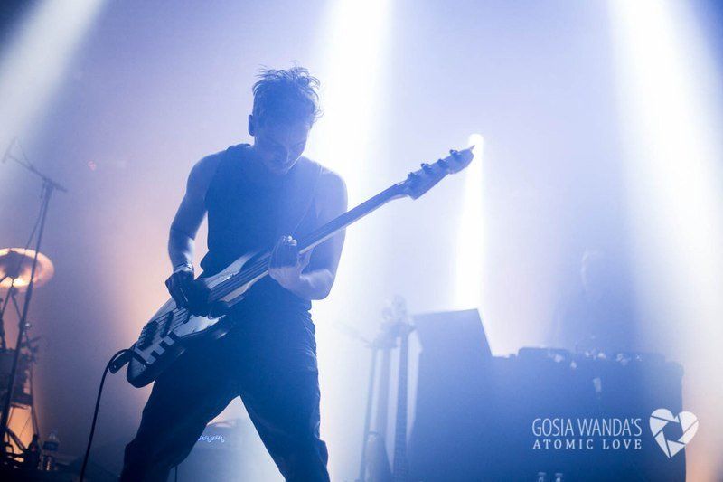 a man is playing a guitar on a stage in the dark .