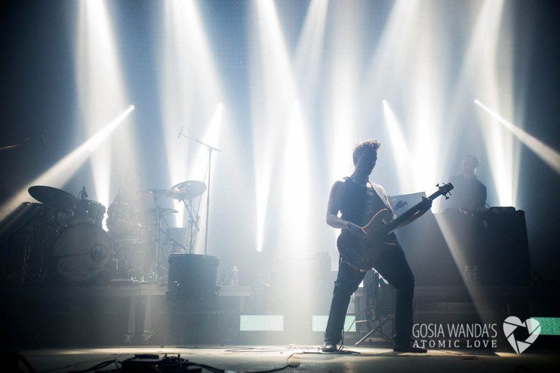 a man is playing a guitar on a stage in front of a crowd .