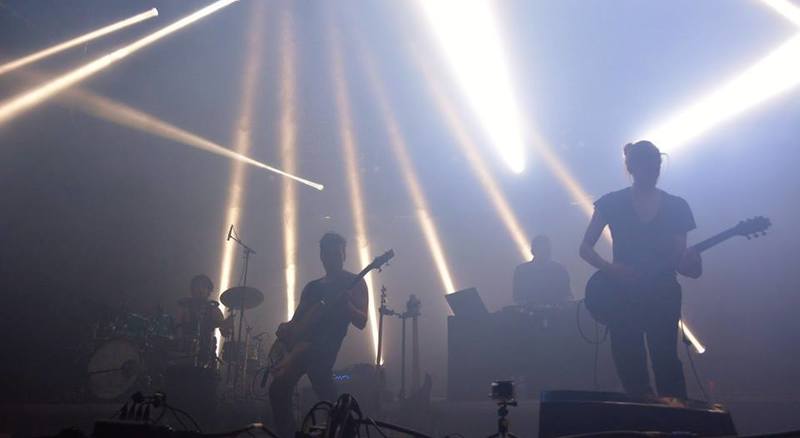 two men are playing guitars on a stage in front of a crowd .